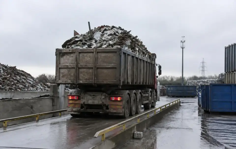 Vrachtwagen met schroot op een weegbrug van een recyclagewerf